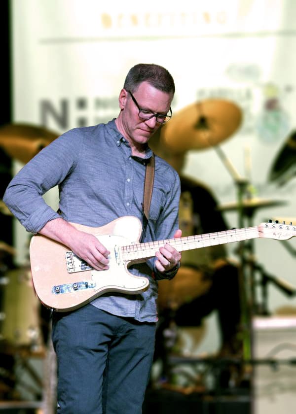 A man playing a guitar at an event