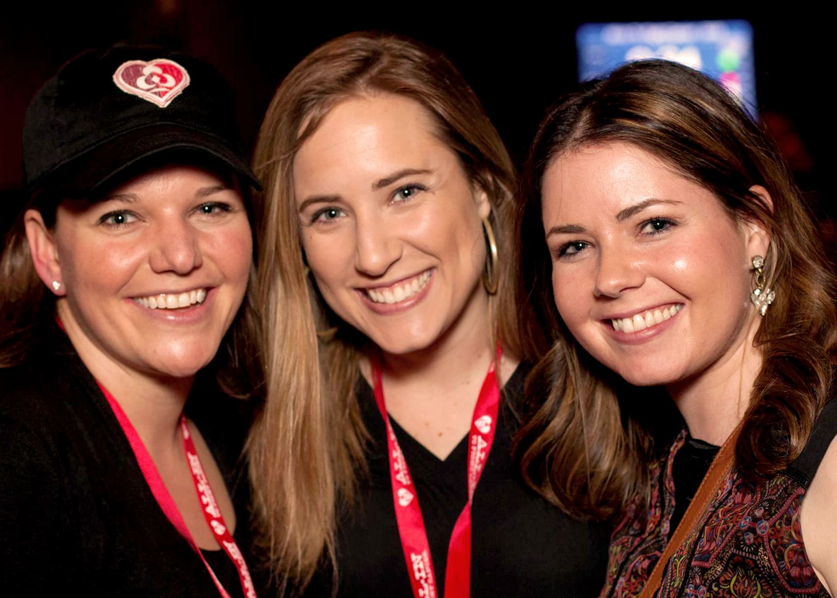 Three smiling women at an All-In event